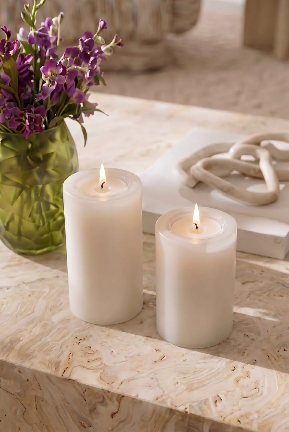 Two Lilianfeld candles on marble with flowers